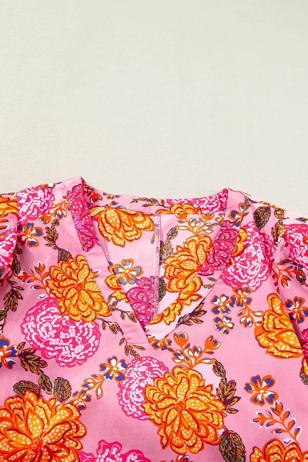 Mini-robe fleurie rose à manches bouffantes et col en V à volants